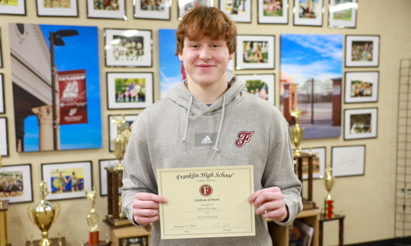 male student holds certificate